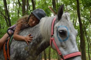 Gyermekek fejlődése: egy kislány ül a lovon